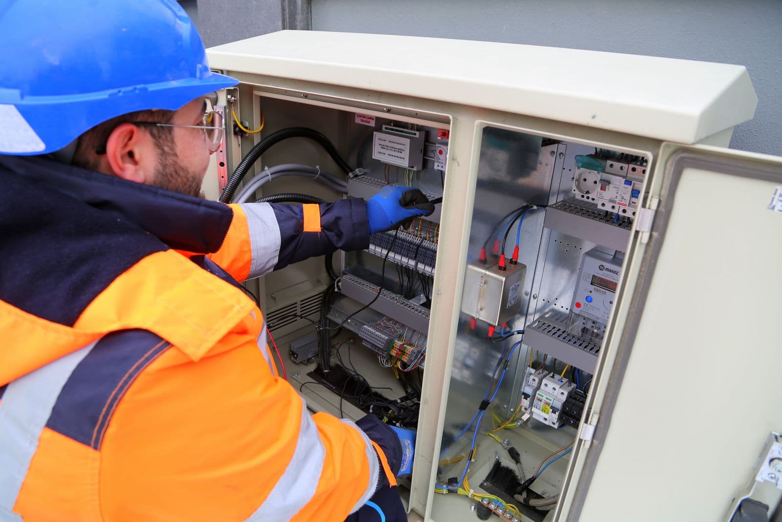 Électricien devant un panneau extérieur